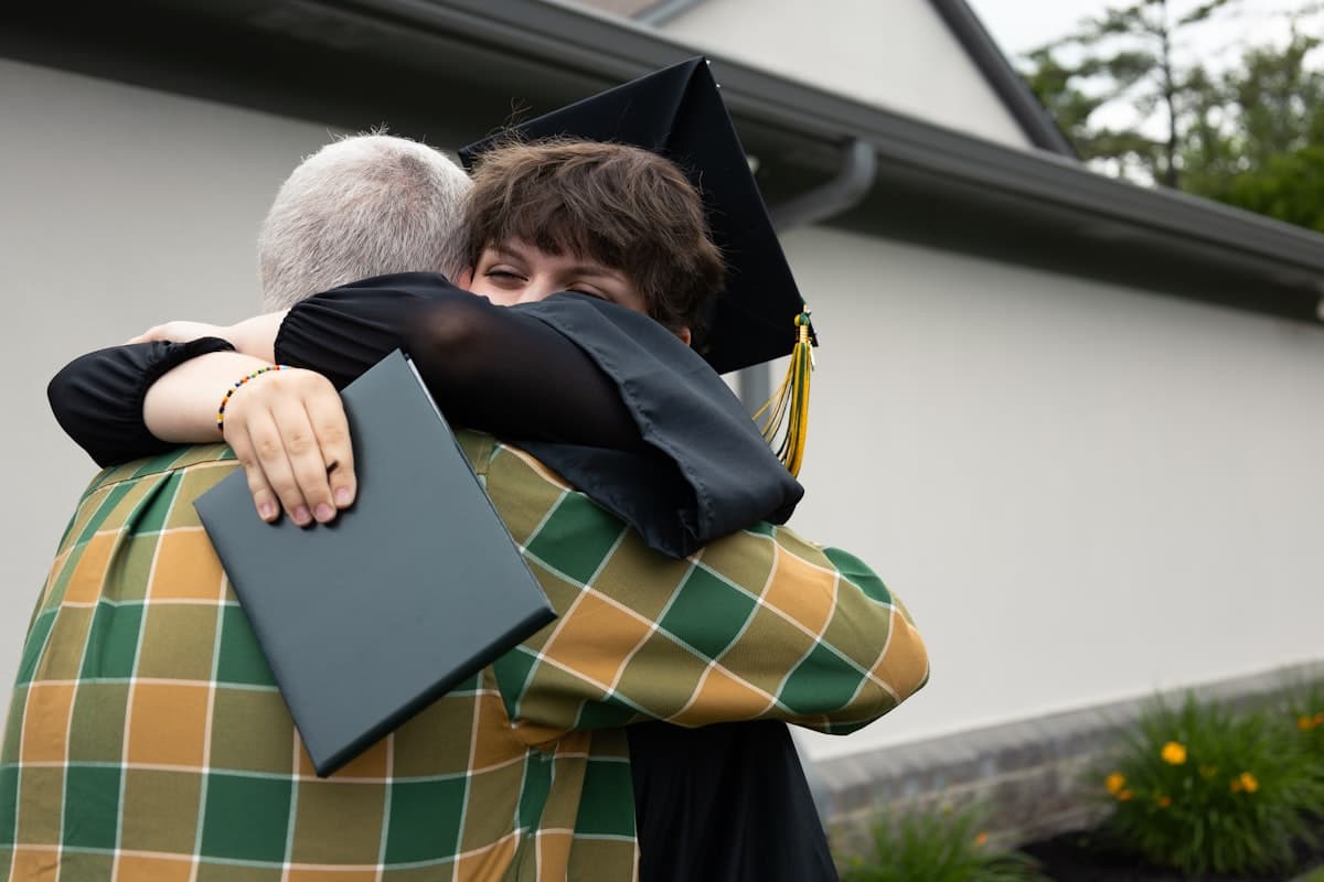 A grandparent embracing their graduate, sharing a proud moment