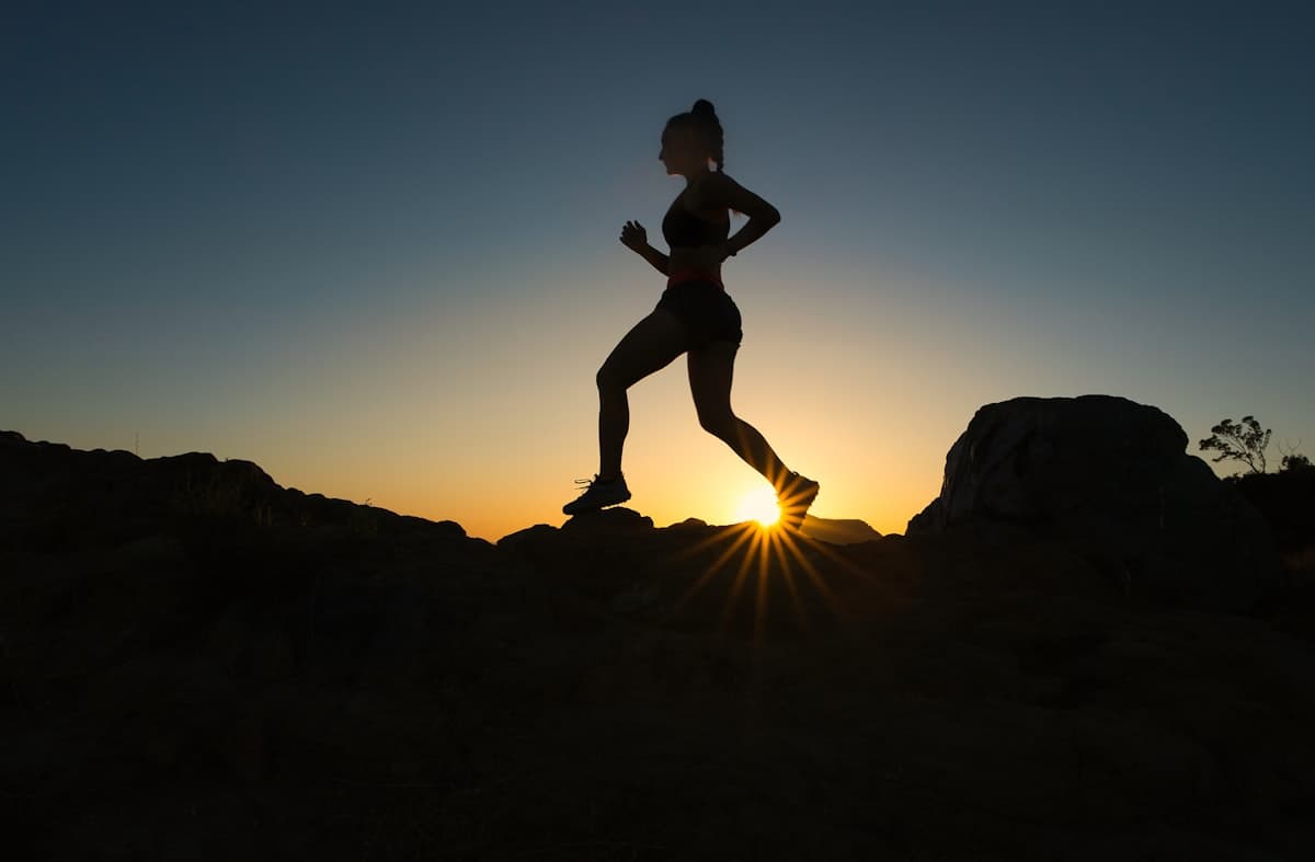 A runner silhouetted against the sunrise, mid-stride